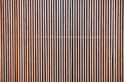 Wood cladding wall which various tone texture of wooden stripes use as partition or seamless fence in vertical line which use as building facade decoration and modern household or contemporary office.