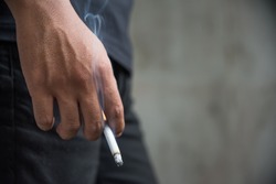 Close up male hand holding a cigarette.