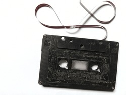 black tape cassette broken on a white background. music, objects, technology