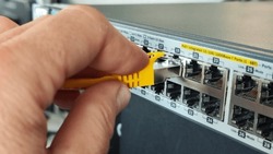 Man connecting network cable to switch