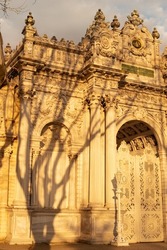 Dolmabahche Palace entrance in Istanbul, Turkey at sunset light.Beautiful tree shadow.Beauty of turkish architecture concept.