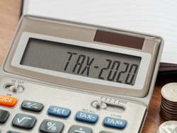 Tax word and 2020 number on calculator. Business and tax concept. Pay tax in 2020 years.