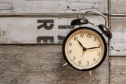 Black retro alarm clock on wooden background