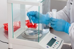 Scientist using an analytical balance at laboratory