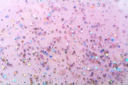 Texture of pink gel with sparkles. Glitter texture with sequins. Nail polish gel.