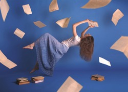 Surreal creative design, levitation. Flying woman. Levity people. Reading girl. Pages of books flying in the air. Floating in the air magic book.