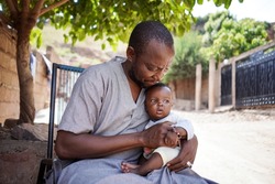 Close up African ethnicity father hold with care his small beautiful innocent child in his hands