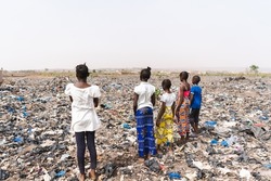 Group of African children contemplating the immense expanse of an illegal dump