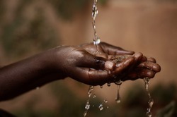 Social Issues: Water Pouring in African Child's Hands