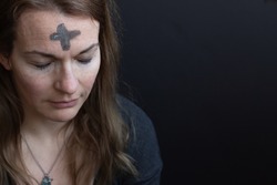 Ash cross on woman's forehead