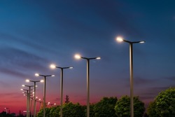 Modern street LED lighting pole. Urban electro-energy technologies. A row of street lights against the night sky