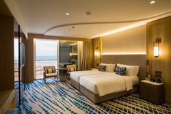 Hotel room interior. Modern hotel. Seaside resort. Sea view. Bedroom interior. Cozy bedroom. Big double bed. Bedroom furniture. 