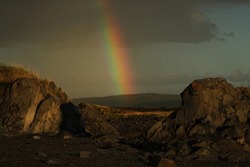 beautiful rainbow on a background of stones on a northern Norwegian evening after rain 