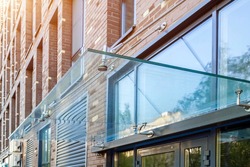 Transparent glass awning over front door of multistory brick apartment building