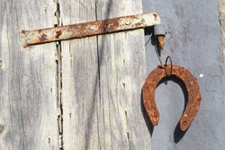 Close up of rusty bolt with horseshoe on old wooden window