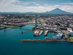 Manado City, North Sulawesi Province, Indonesia. the view from above with the Manado Ship Harbor, the landmark of the Sukarno Bridge and the background of Mount Klabat.
