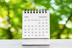 September 2022
 desk calendar for planners and reminders on a black table on the natural background green .
