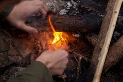 A man makes a fire with dirty hands. Making a fire in close-up.