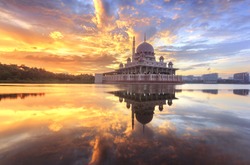beautiful sunrise At Putra Mosque, Putrajaya Malaysia with colorful clouds and reflection on the lake surface