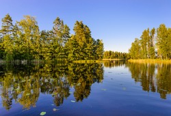 Evening view of Lake Haukivesi with reflection of trees in the water. Rantasalmi, Haukivesi lake, Saimaa lake system, Finland.