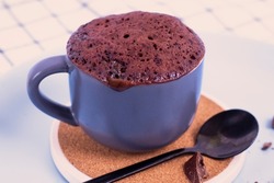 mini cake. Breakfast in a mug. mugcake is microwaved. Homemade cupcake in a mug is on a plate. Chocolate brownie mug cake. Easy cooking concept, microwave baking. muffin chocolate. chocolate biscuit.