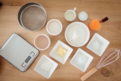 A set of ingredients and tools for baking an orange cake.