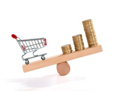 Inflation. Shopping and money. Coin and shopping trolley on wooden seesaw. Supermarket shopping trolley. Concept of growth of food sales, growth of market basket or consumer price index.