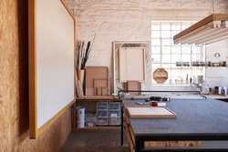 Interior of the workshop area of a picture framing studio with a variety of tools and different sized wooden frames