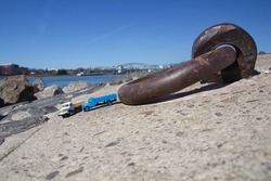 View of a rusted steel ring on the banks of the Rhine in Cologne Poll. Two parked miniature trucks can also be seen in the close-up.
blue sky