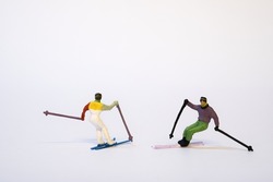 Miniature skier in action, white background, copy space