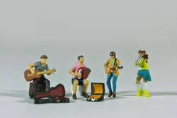 Street music band isolated on light background, miniature figures scene