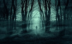 man on dark forest road at night, horror halloween landscape