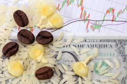 Coffee bean, rice, and corn on dollar and candle stick chart background. Conceptual image of commodity trading.