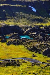 A high-angle view of the big boulders and turquoise ponds of beautiful Storurd valley, East Fjords, Iceland