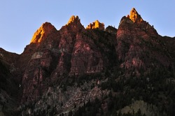 Late afternoon alpenglow on the jagged peaks of Sievers Mountain South, near Maroon Bells and Maroon Lake, White River National Forest, Aspen, Colorado, USA