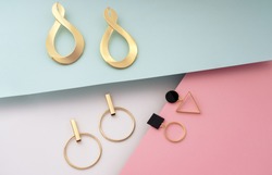 Golden modern stud geometric earrings on colorful background