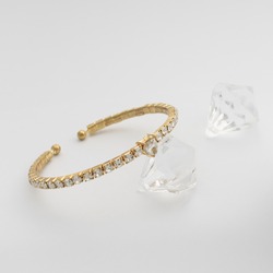 Golden bracelet with brilliants on white background
