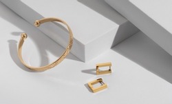Geometric modern bracelet and earrings pair on white geometric background 