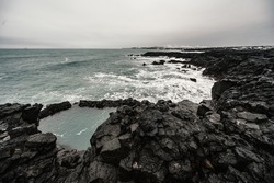 Brimketill lava rock pool - natural pool at the bottom of the cliffs, located on the Reykjanes Peninsula, west of the Grindavik, Iceland.