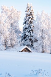 Snowy winter landscape of Lapland. Wooden, village houses covered with thick snow.