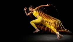 Action, motion. Young woman, female professional track athlete running isolated over black studio background in mixed neon lights. Stroboscopic effect.