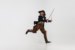 Portrait of man, medeival pirate in vintage costume with sword running away isolated over white background. Combination of medeival and modern styles. Concept of history. Copyspace for ad.