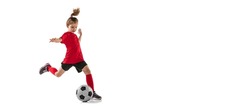Portrait of sportive child, girl in red uniform playing, training football isolated over white background. Concept of action, sportive lifestyle, team game, health, energy, vitality and ad