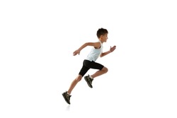 Side view portrait of little boy in motion, running isolated over white studio background. Concept of action, sport, healthy life, competition, motion, physical activity. Copy space for ad
