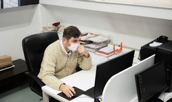 Man working in the office during the pandemic period. Ways to be protected from Covid19.  With Mask.