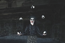 creepy hypnotic juggler clown play with balls
