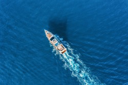 Yacht at the sea in Europe. Aerial view of luxury floating ship at sunset. Colorful landscape with boat in marina bay, blue sea. Top view from drone of yacht. Luxury cruise. Seascape with motorboat