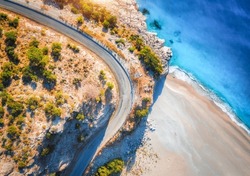 Aerial view of mountain road near blue sea with sandy beach at sunset in summer. Oludeniz, Turkey. Top view of road, trees, azure water, mountain. Beautiful landscape with highway, rocks, sea coast	