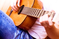 Guitar instrument. Musician or guitarist. Music, musical sound. Finger, hand on string. Acoustic concert closeup. Player play chord. Wood jazz, rock performance. Fretboard. 