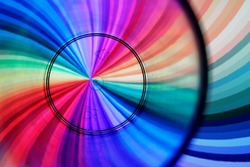 Black concentric circles of a pitcher for liquids, form an original abstract design with multicolored swirl background in bokeh